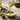 Olive oil beong poured in small bowl with olive to side