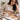 Lady at desk with breakfast with her hand on her stomach